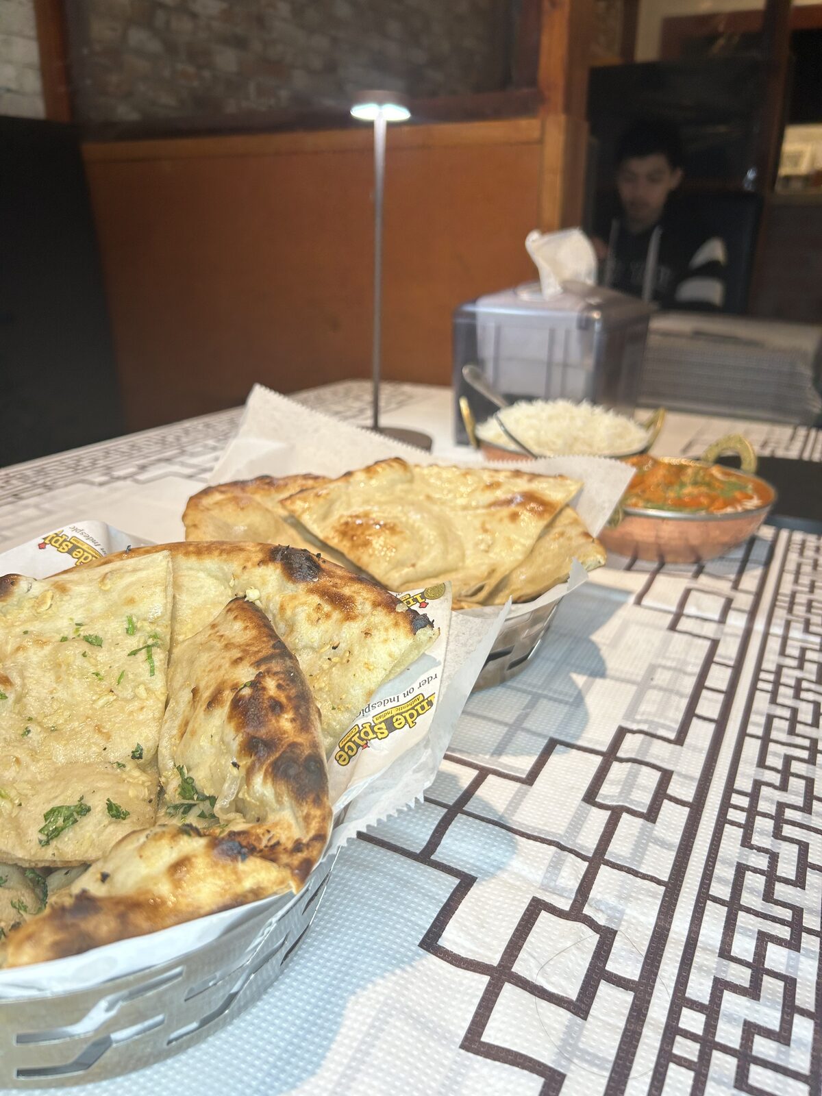 Naan basket with basmati rice and chicken curry table spread