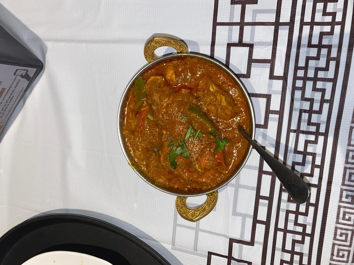 Chicken karahi simmered in spiced tomato gravy with peppers and cilantro