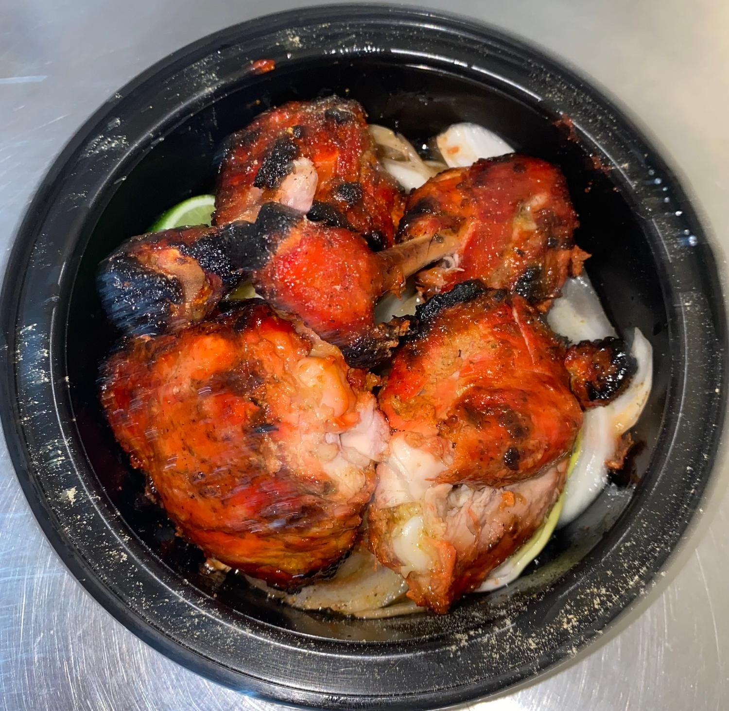 Tandoori chicken drumsticks over onions with lime