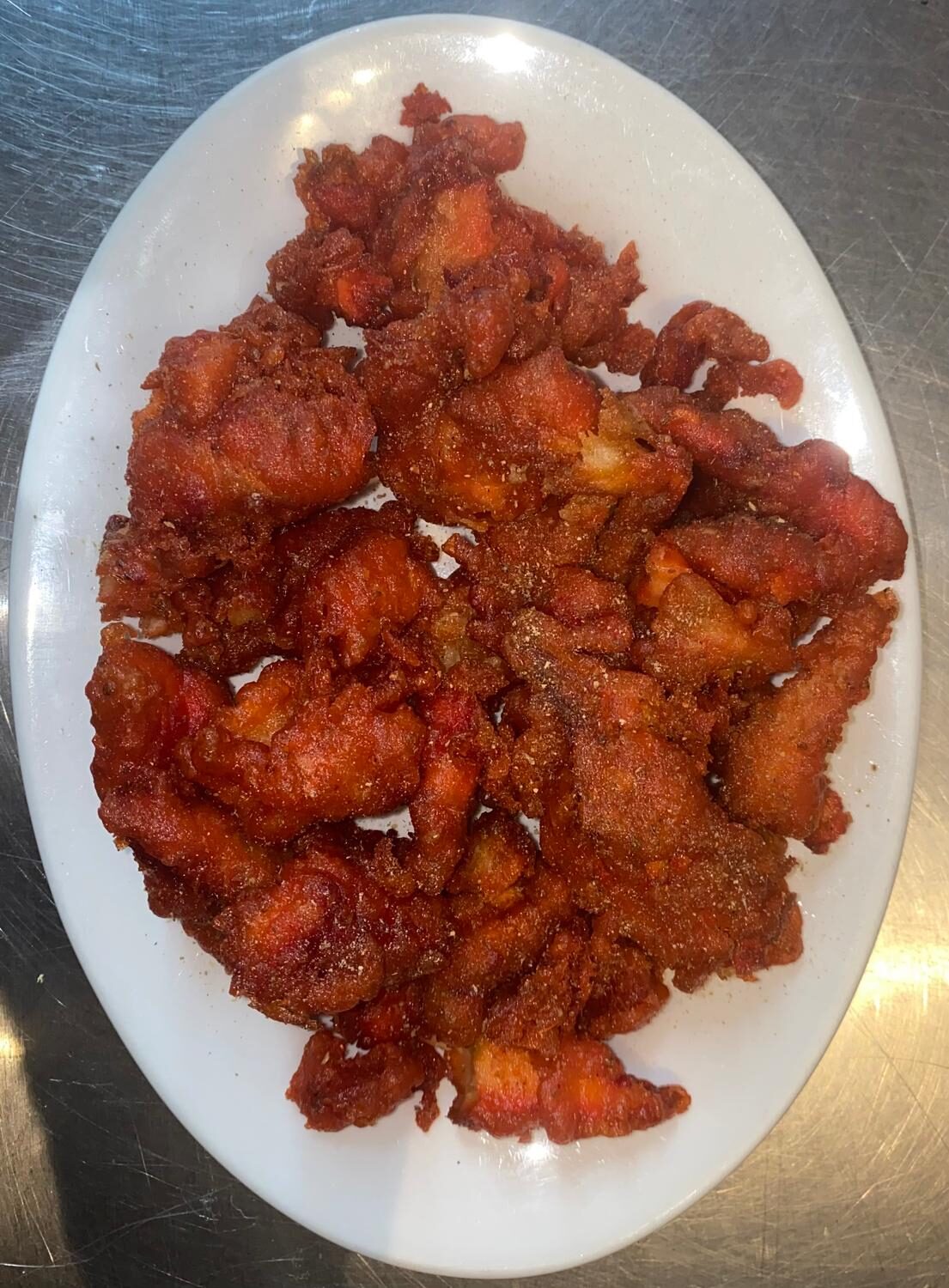 Crispy chicken pakora fritters on a white platter