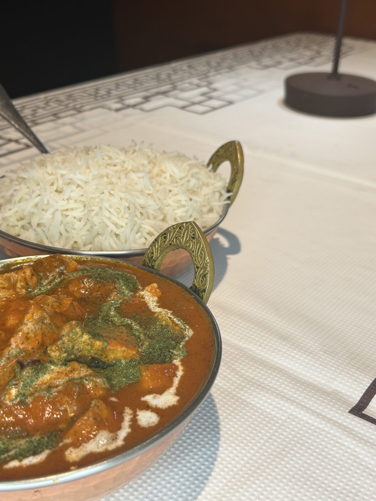 Chicken curry in a copper karahi paired with fluffy basmati rice