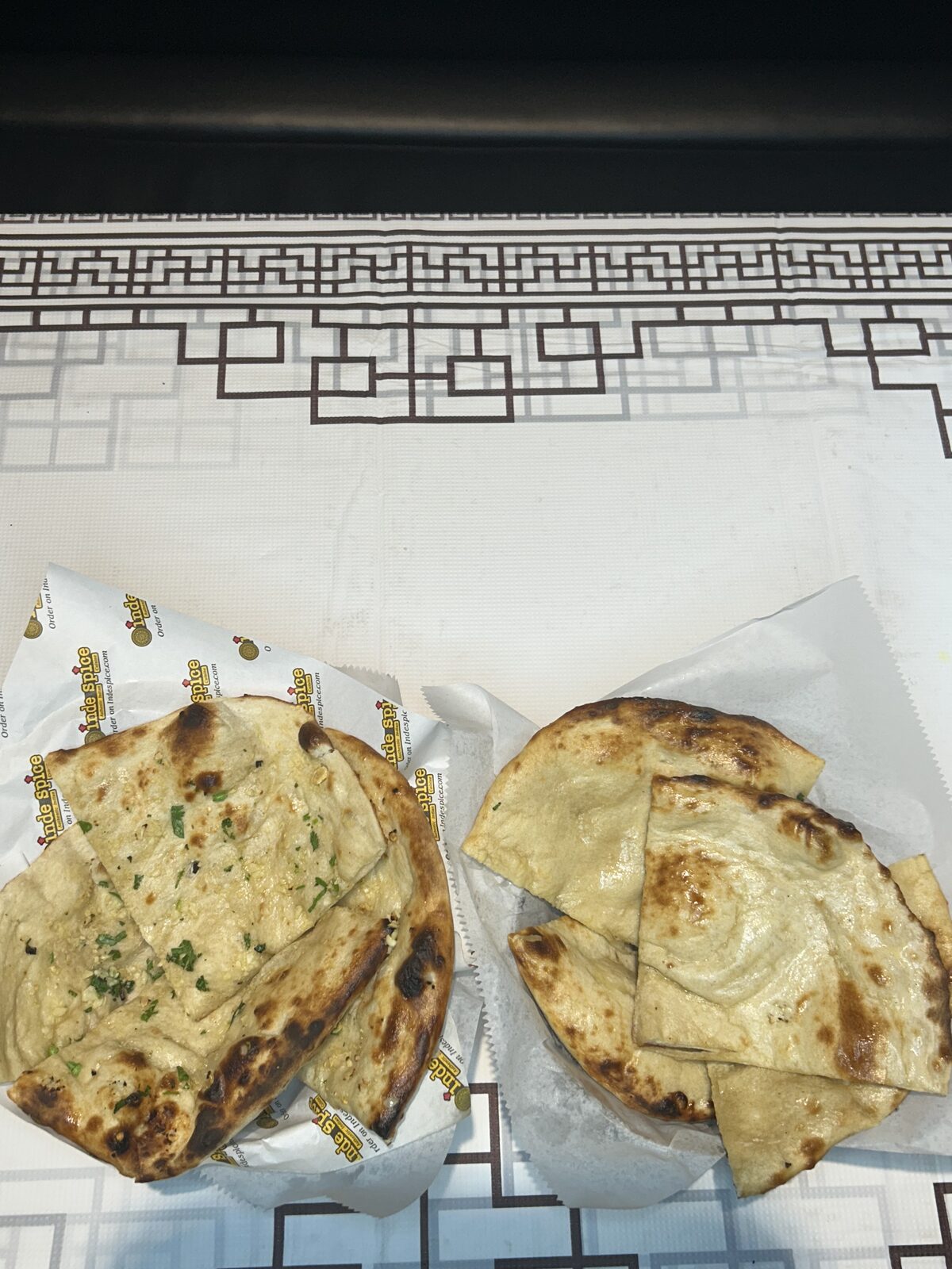 Fresh garlic naan and plain naan wrapped in INDE SPICE paper